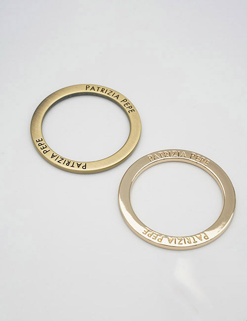 Two gold circular metal rings from YIPAIs Rings & Slides collection are shown on a plain white surface, each engraved with the brand name.