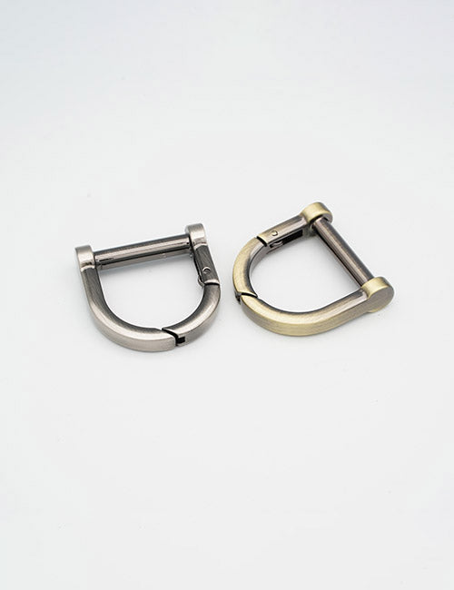 Two YIPAI Rings & Slides metal D-ring buckles, one silver and one brass, with hinged pin mechanisms are displayed side by side on a plain white background.