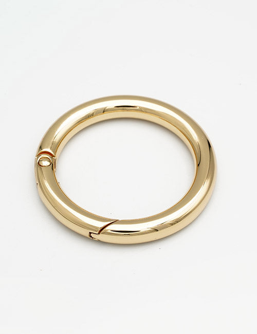 The YIPAI Rings & Slides is a shiny, circular gold keyring featuring a smooth, polished surface and a hinged opening, shown against a plain white background.