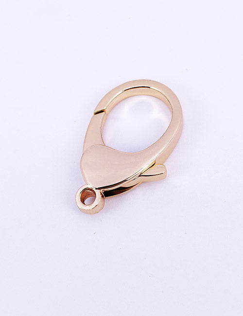 A YIPAI Snap Hook in gold color with a small circular hole at the base rests on a light background.