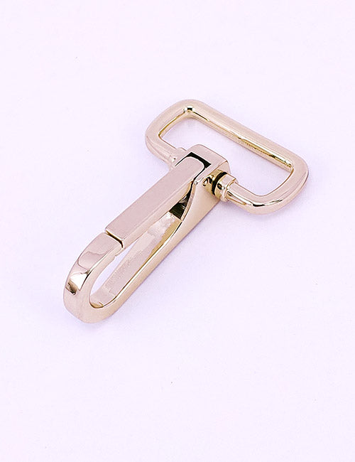 The YIPAI Snap Hook features a shiny gold-colored metal swivel clasp with a rectangular loop on one end and a spring-loaded latch on the other, displayed against a plain light pink background.