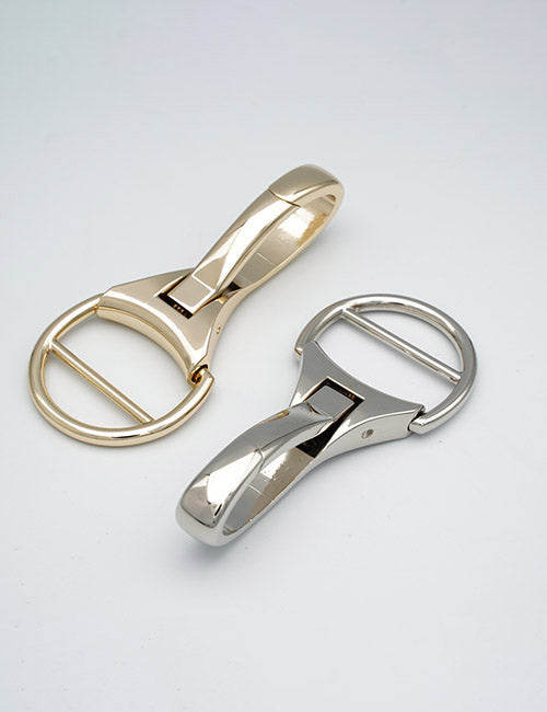 Two YIPAI Snap Hooks, one gold and one silver, are displayed on a plain white surface. They both feature a shiny finish and a modern, curved design.